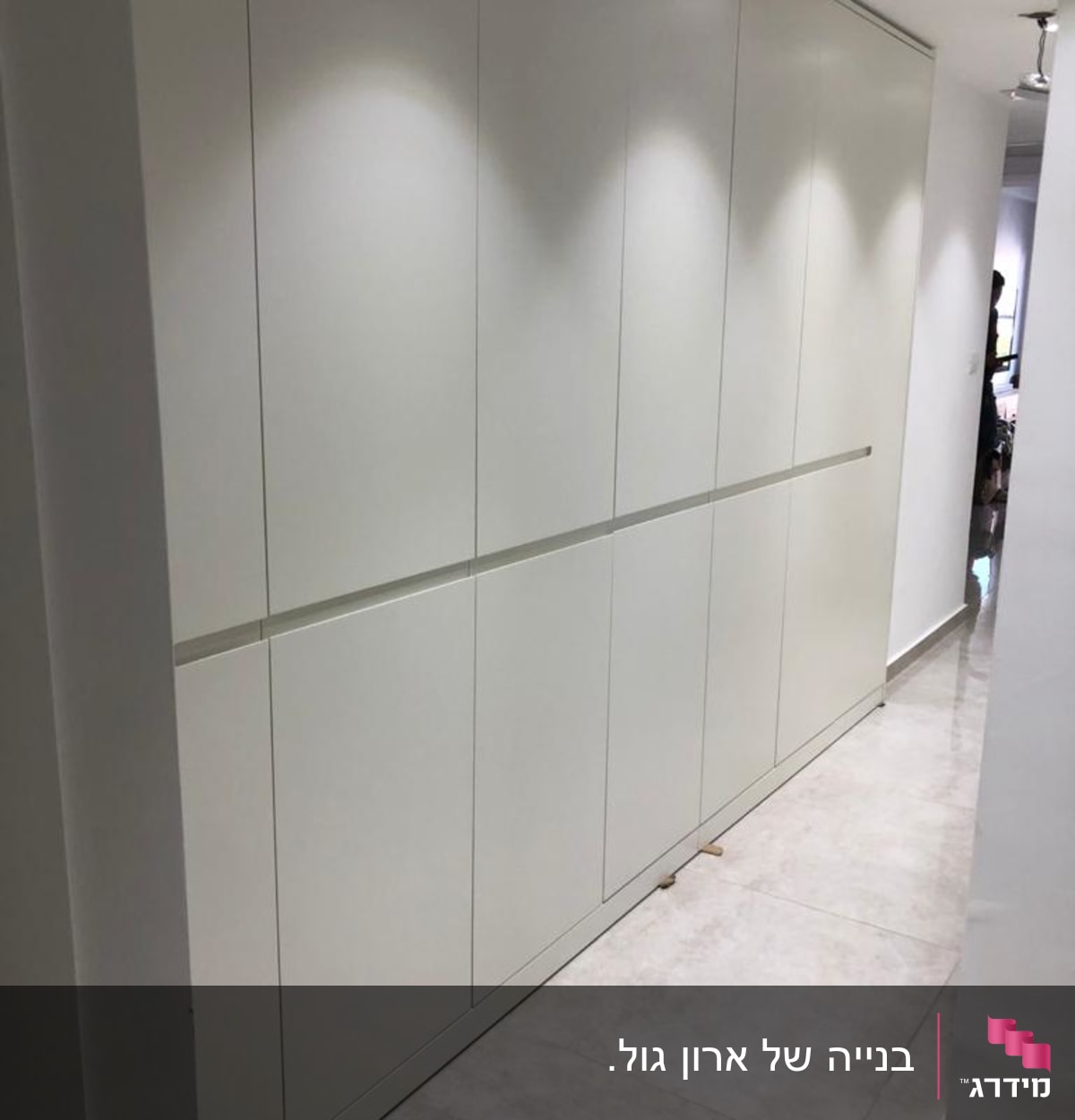 ארון קיר לבן עם דלתות חלקות במסדרון